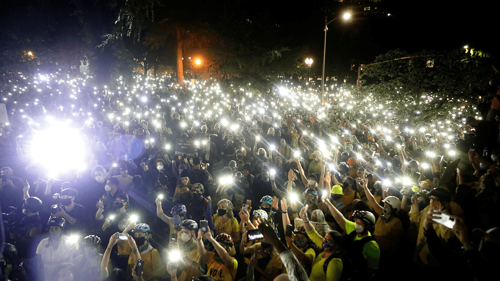 Peaceful march with protesters holding lit mobile phones